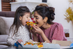 mom and daughter eating pizza
